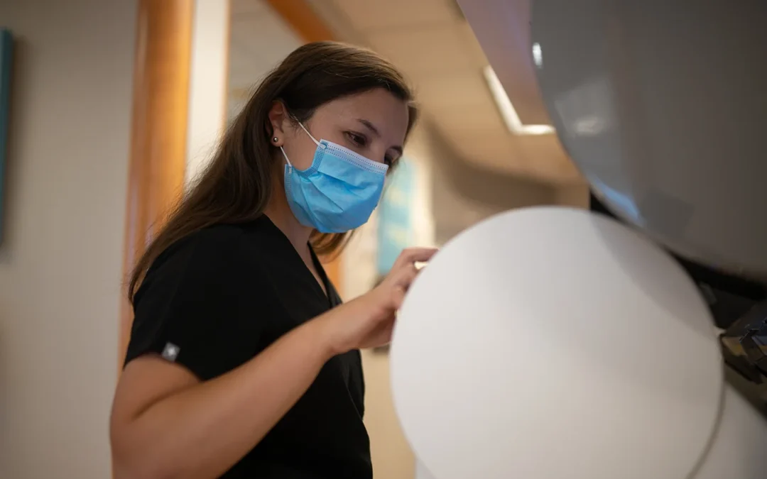 Dental team member operating equipment during patient care at Best Natural Smile