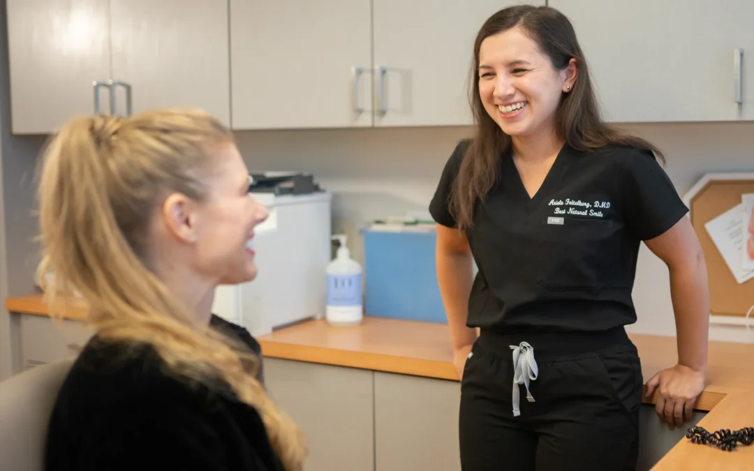 Smiling dentist talking with a staff member inside Best Natural Smile