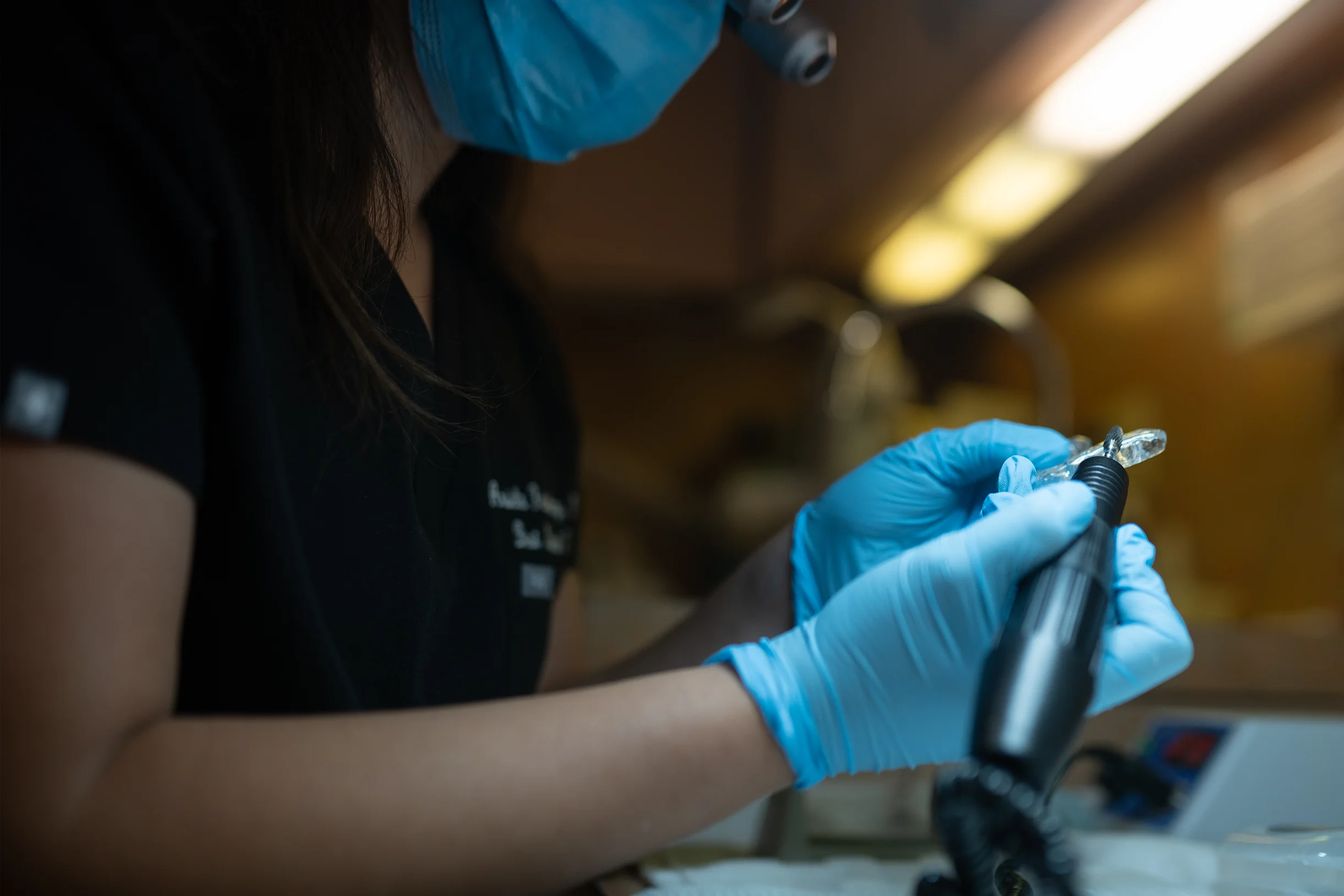 Dentist polishing a dental appliance with precision tools at Best Natural Smile