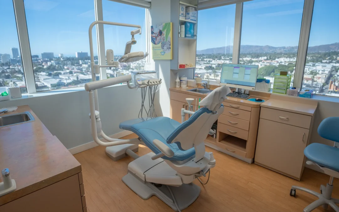 Bright dental operatory with a blue patient chair, large windows, and equipment at Best Natural Smile.