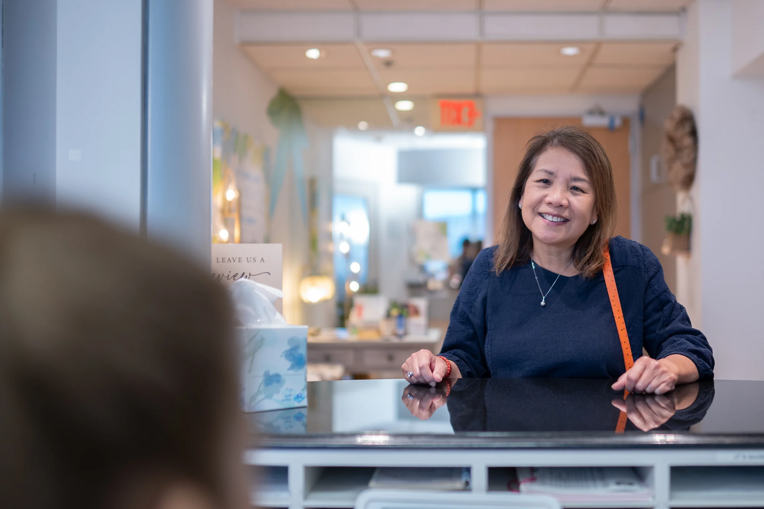 Smiling patient checking in at the front desk of Best Natural Smile.